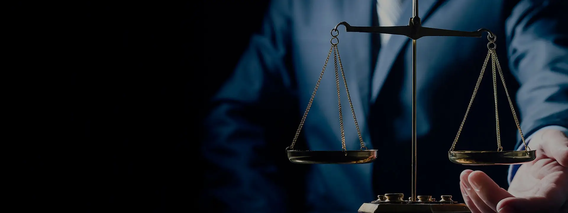 Advogado de terno segurando balança da justiça dourada, close-up dramático em fundo escuro, iluminação azulada solene, simbolizando equilíbrio e justiça, fotografia profissional institucional